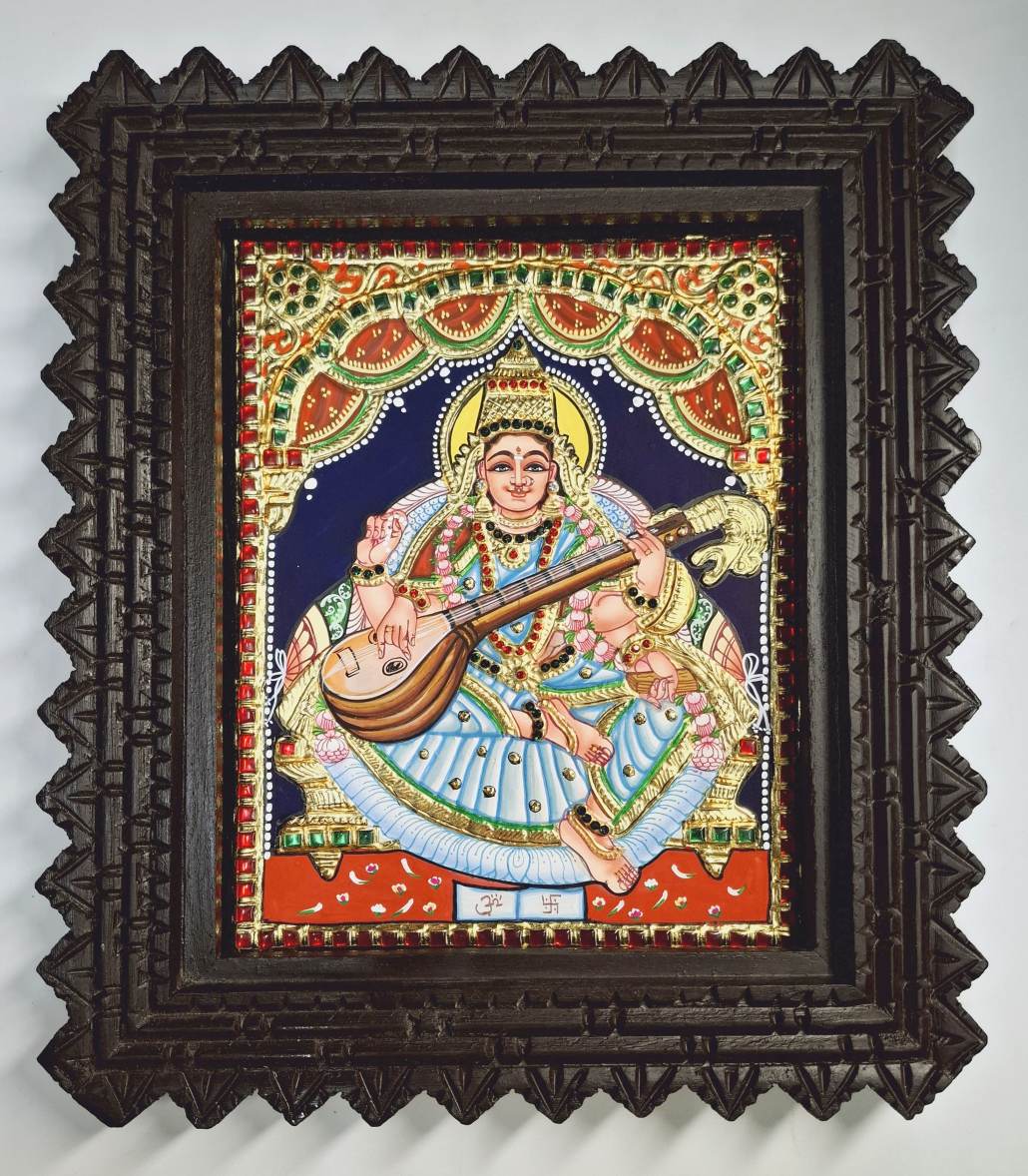 Framed 13x11 inch Saraswathi Tanjore Painting with 22K gold foil and teakwood – traditional Indian artwork for home or gifting.