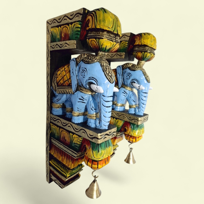 A pair of wooden elephant wall corbels by JLine Arts, featuring a vibrant color finish and hanging brass bells. These hand-carved wall brackets are perfect for door entrance wall decor or as unique wall hangings.