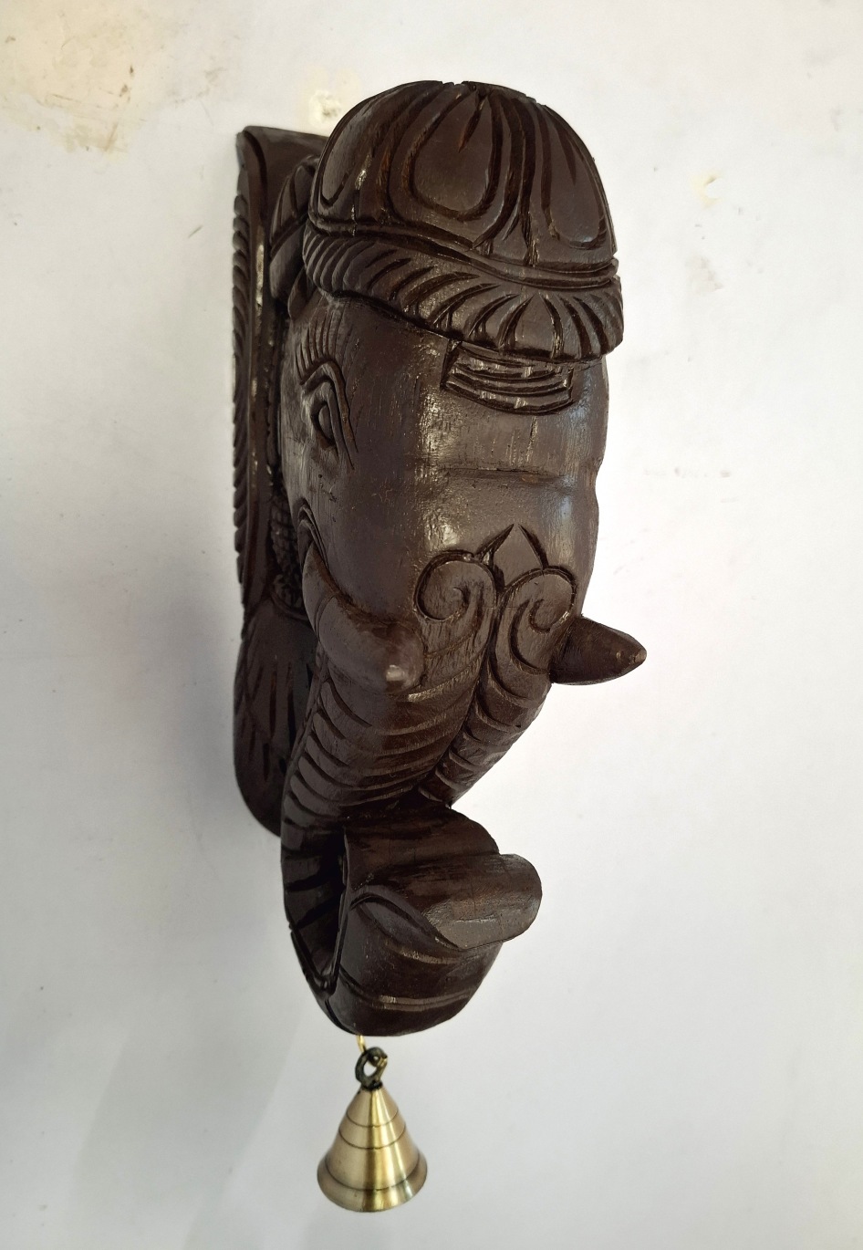 The Wooden Elephant Head Big Corbel is a striking Indian wood carving featuring a brass bell on the trunk, ideal as an elegant wall display.