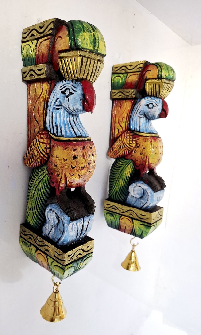 Set of 2 hand-carved wooden peacock bird wall brackets with brass bells. Vibrant multicolor — blue, green, gold, red. South Indian temple bird design, 12x4x2 inches each. Ready to hang. Perfect for puja room or housewarming gift. Ships free from India.