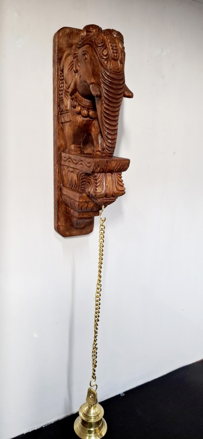 25-inch hand-carved wooden elephant wall bracket with brass bell and chain in antique brown finish, traditional South Indian temple décor.