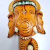 Vibrant Wooden Ganesha Head Sculpture with intricate details, showcasing a green and orange headdress and a curved trunk, mounted on a white background. Known as the Ganesha Statue Wall Decor, this Hindu Deity piece is ideal for meditation and house decor.