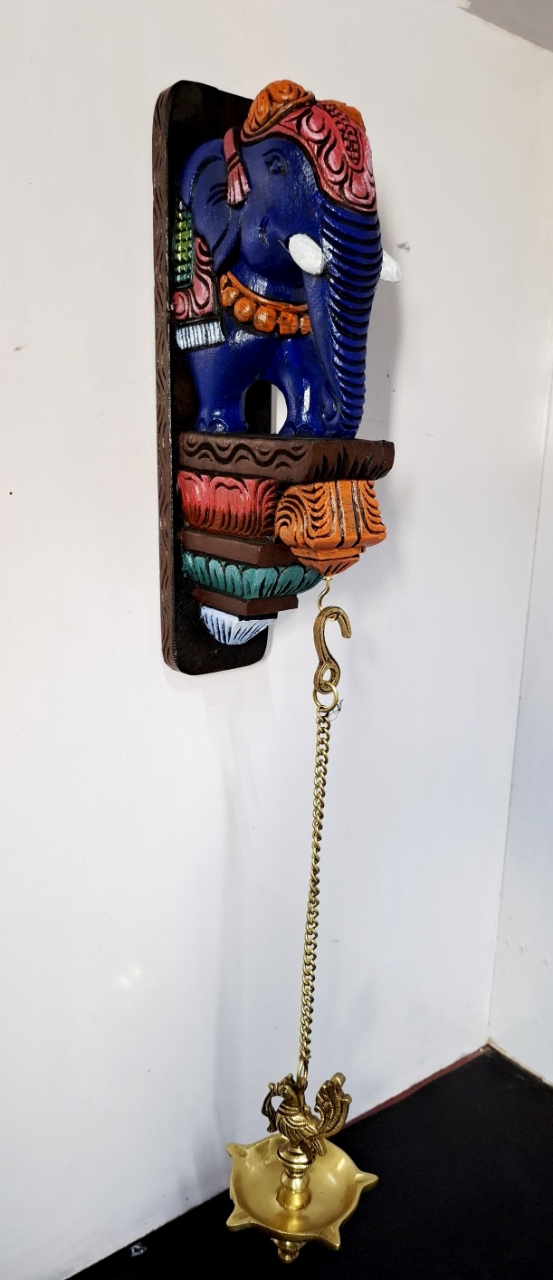 27-inch multicolor hand-carved wooden elephant wall bracket with brass peacock diya and hanging chain, South Indian temple-style wall décor.
